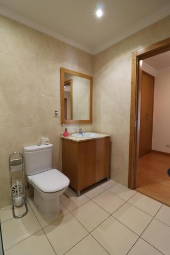 a bathroom with a toilet and a sink and a mirror at BeGuest Cascais INN Apartments_ Ocean View in Alcabideche