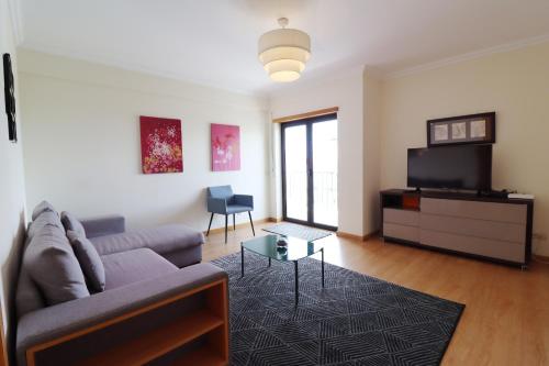 a living room with a couch and a tv at BeGuest Cascais INN Apartments_ Ocean View in Alcabideche
