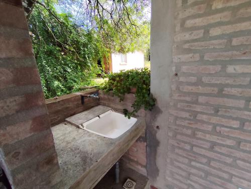 a bathroom with a sink in a brick wall at Cabañas Margus in La Granja