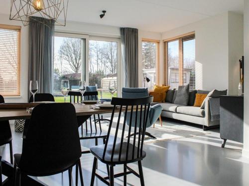 a living room with a dining table and chairs at Villa in Friesland with Jetty and Fenced Garden in Idskenhuizen