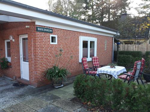 a small brick house with a table and chairs at Haus Birkenheim in Kirchhatten