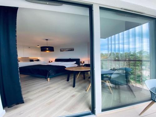 ポビエロボにあるA comfortable apartment near the sea for 3 people, Pobierowoのベッドルーム1室(ベッド1台付)、バルコニーが備わります。