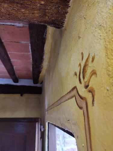 a painting on the side of a room with a door at Podere Rinascidentro in Asciano