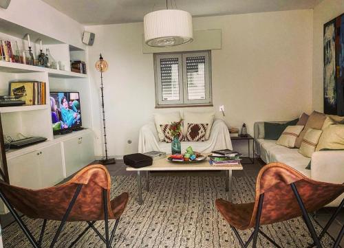 a living room with a couch and a table and chairs at Trullo Sasamaka Ostuni in Carovigno