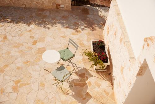 an overhead view of a table and chair and flowers at Trullo Sasamaka Ostuni in Carovigno