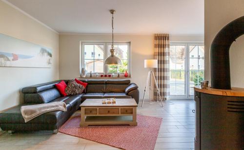 a living room with a leather couch and a coffee table at Seeigel in Zingst