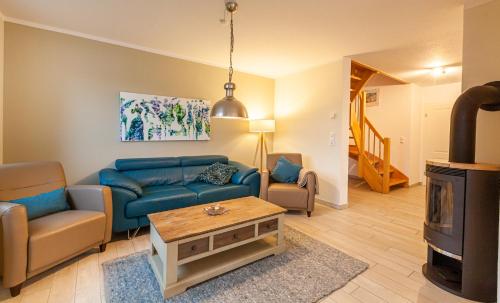 a living room with a blue couch and a fireplace at Seewolf in Zingst