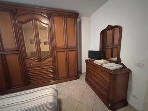 a bedroom with a bed and a wooden dresser at Casa Marisa in Ponsacco