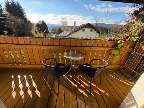 a patio with a table and chairs on a wooden deck at Apartmány Šumava Boubín in Zátoň