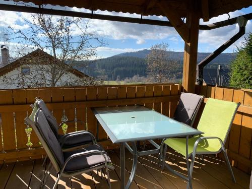 a table and chairs on a deck with a view at Apartmány Šumava Boubín in Zátoň