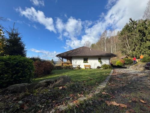 a small white house in the middle of a yard at Apartmány Šumava Boubín in Zátoň