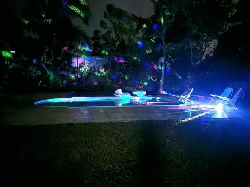 a pool at night with blue and green lights at Recanto da paz in Viamão