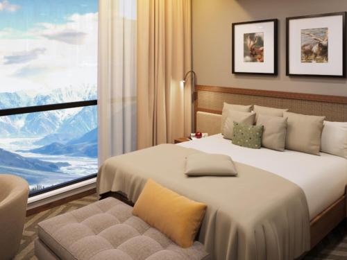 a bedroom with a large bed and a large window at FortuNorth in Skardu
