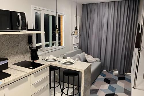 a kitchen and living room with a couch and a table at Vista Para o Mar no 8º Andar conforto e Charme 807 in Salvador