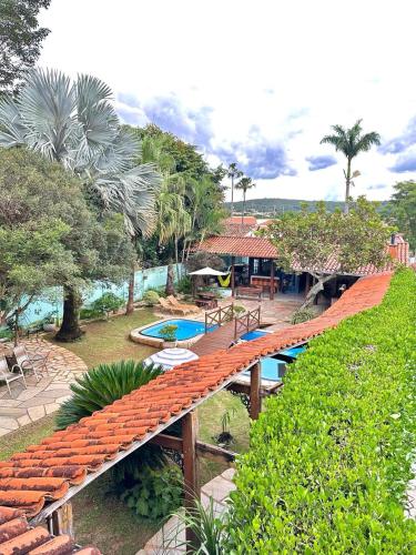 a bridge over a swimming pool in a resort at Pousada das Orquídeas in Pirenópolis