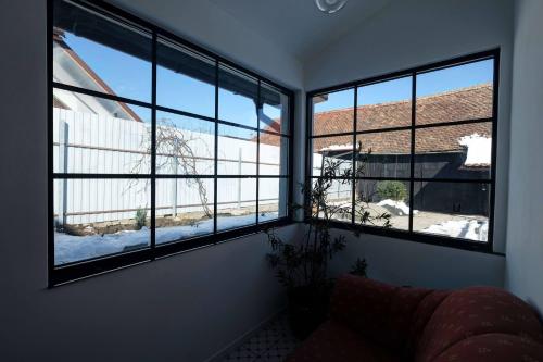a room with three large windows with snow outside at Florian's Haus in Cisnadioara