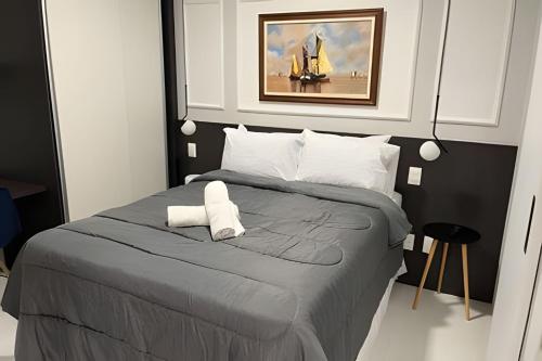 a bedroom with a large bed with a painting on the wall at Studio no 8° Andar Vista de Cinema para o Mar 812 in Salvador