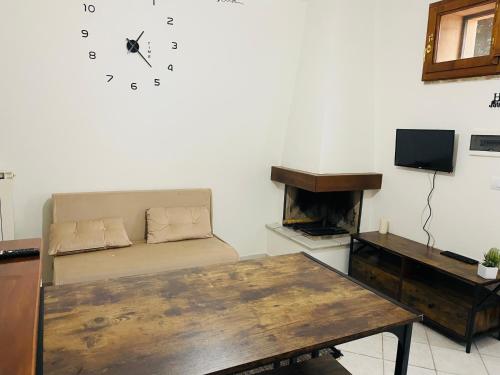 a living room with a couch and a clock on the wall at B&B il Castelletto Siena in Montaperti