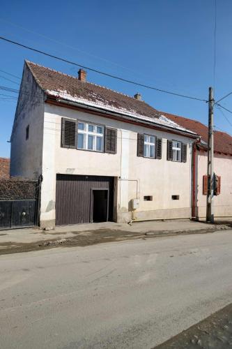 an old white building on the side of a street at Florian's Haus in Cisnadioara
