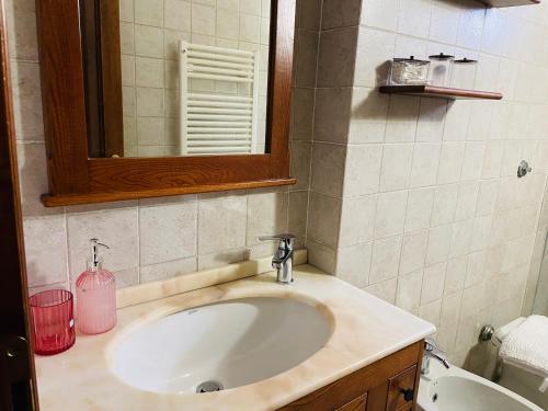 a bathroom with a sink and a mirror at B&B il Castelletto Siena in Montaperti