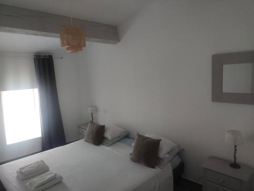 une chambre avec un lit blanc et une fenêtre dans l'établissement Maison, à Lasbordes