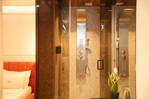 a glass shower in a room with a bed at La Suite Boutique Hotel in Tirana