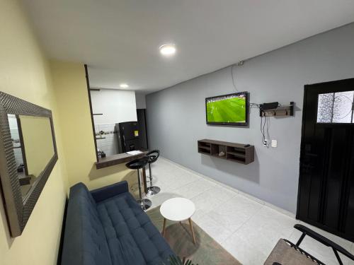 una sala d'attesa con un divano blu e una TV a parete di Punto base aérea a Cali