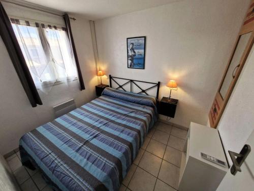 une chambre avec un lit et deux lampes et une fenêtre dans l'établissement Résidence Marina Ile Des Pecheurs - VILLA 3 PIECES 4 couchages LE BARCARES MAE-5894, à Port-Leucate