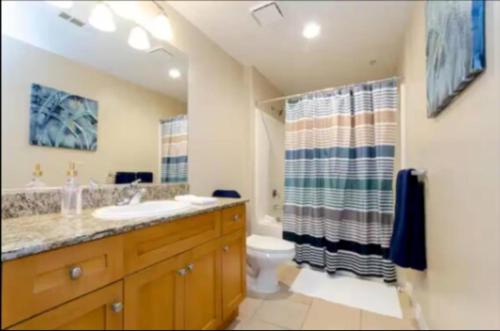 a bathroom with a sink and a toilet and a shower at Spacious 2 Bedroom Apartment Near Disneyland and Anaheim Convention Center in Anaheim