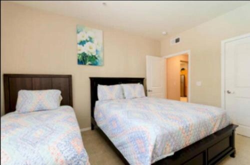 a bedroom with two beds and a painting on the wall at Spacious 2 Bedroom Apartment Near Disneyland and Anaheim Convention Center in Anaheim