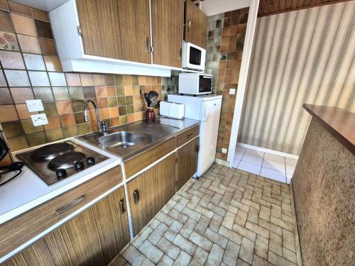 une petite cuisine avec un évier et un réfrigérateur dans l'établissement Résidence Montcalm B - Belle vue dégagée pour ce logement ! MAE-6664, à Aix-les-Bains