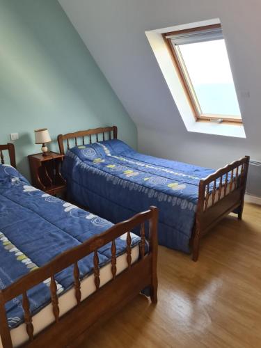deux lits dans une chambre avec une fenêtre dans l'établissement maison face à la mer, à Trégunc