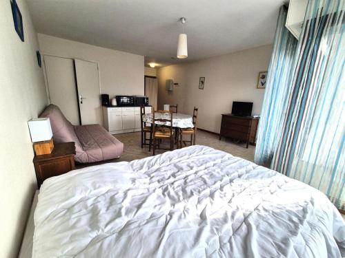 - une chambre avec un lit blanc et une salle à manger dans l'établissement Résidence Le Chateau Durieux 3 - Studio spacieux et proche tous commerces ! MAE-7464, à Aix-les-Bains