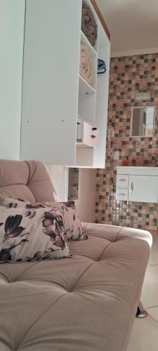 a couch with a pillow on it in a room at Parada Di Maria Guest House in Campos do Jordão