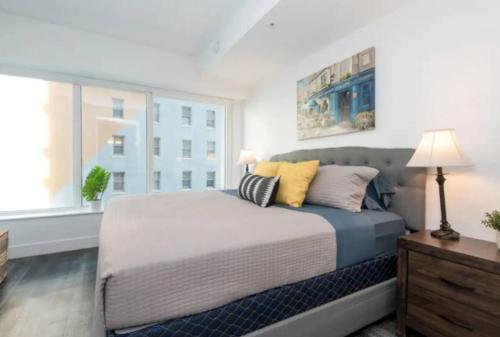 a bedroom with a bed with pillows and a window at Modern 3 Bedroom High-Rise with resort Pool in Los Angeles