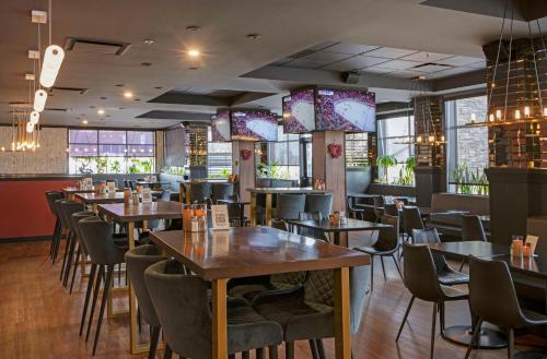 a dining room with tables and chairs and windows at Best Western Premier Aberdeen Kamloops in Kamloops