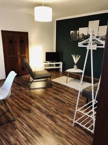 a living room with a hardwood floor and a white ladder at Ferienwohnung Willi I in Spremberg