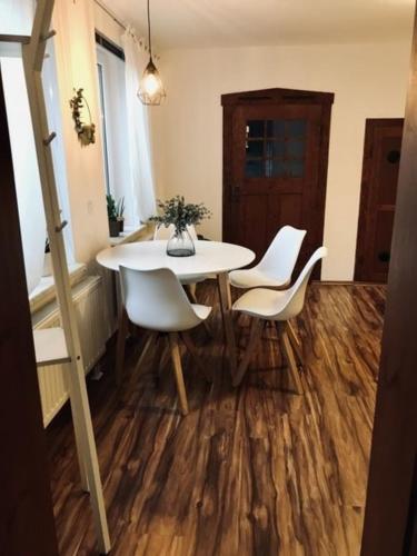 a dining room with a table and white chairs at Ferienwohnung Willi I in Spremberg
