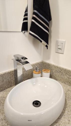 a white sink in a bathroom with black towels at Morada City Hostel in Sao Paulo
