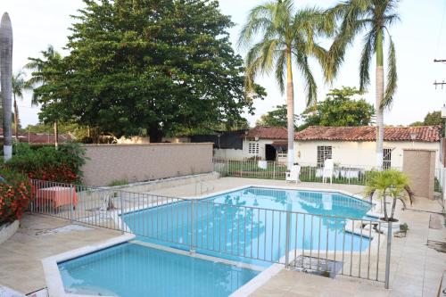 a swimming pool in a yard with palm trees at Hotel Plaza Real Montelíbano in Montelíbano