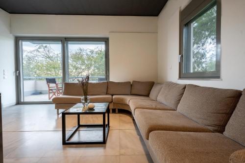 a living room with a couch and a table at Athenian Riviera Seafront Residence in Saronida