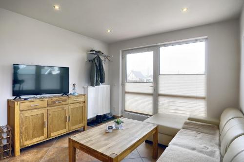 een woonkamer met een bank en een flatscreen-tv bij Haus Havelland in Zingst