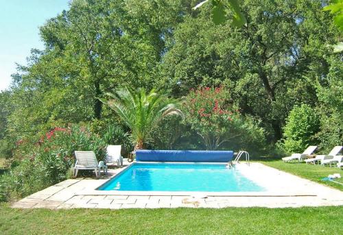 - une piscine dans une cour avec des chaises et des arbres dans l'établissement La Mude, à Salernes