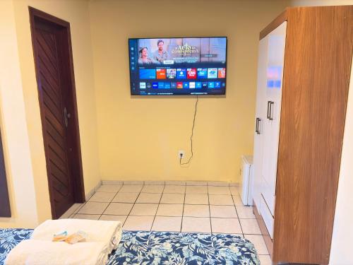 a room with a tv on the wall and a bed at Terra do Sol Pousada e Hostel in Porto Seguro