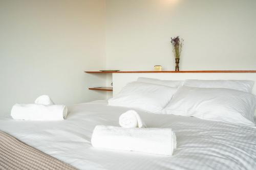 a white bed with white sheets and towels on it at Athenian Riviera Seafront Residence in Saronida