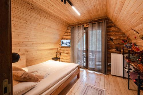 a bedroom with a bed in a wooden room at Aurum Cabins in Zlatibor