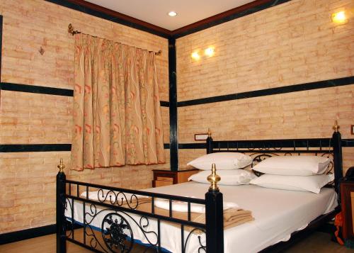 a bedroom with a black bed with white pillows at Hotel Hira in Mumbai