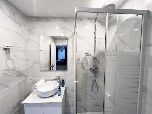 une salle de bain blanche avec une douche et un lavabo dans l'établissement Urban Flat 17 - Pretty 3 BDR Flat in Paris Montorgueil, à Paris