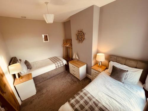 1 Schlafzimmer mit 2 Betten und 2 Lampen in der Unterkunft Delightful 3 bedroom Cottage in Haverigg in Haverigg