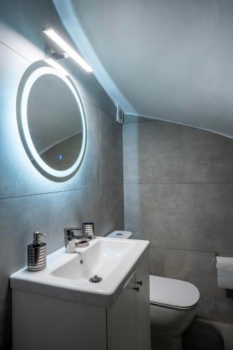 a bathroom with a sink and a toilet and a mirror at Athenian Riviera Seafront Residence in Saronida